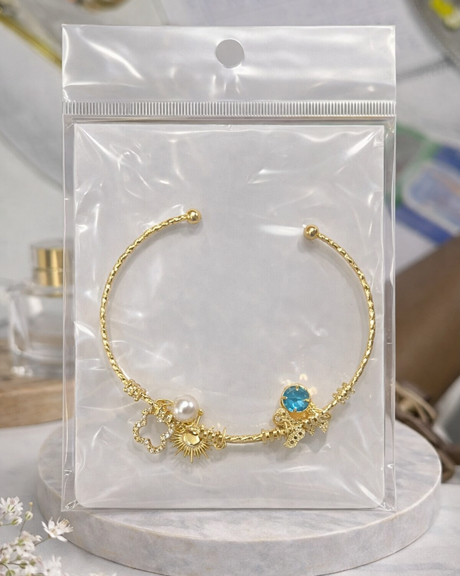 Gold Charm Open Cuff Bracelet – Sun, Pearl & Blue Crystal Design
